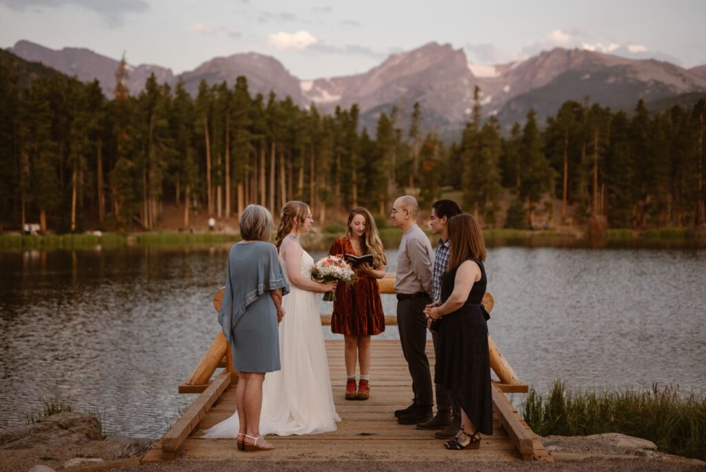 Small wedding ceremony with a lake, trees, and mountains in the distance