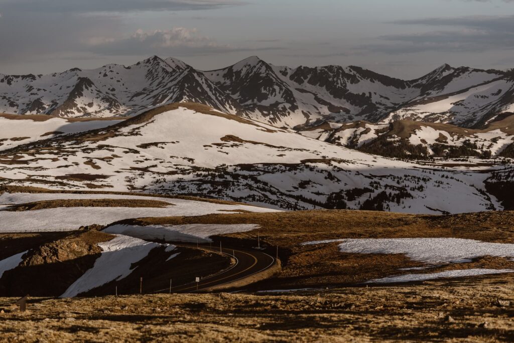 View of snowy Trail Ridge Road at sunrise in June