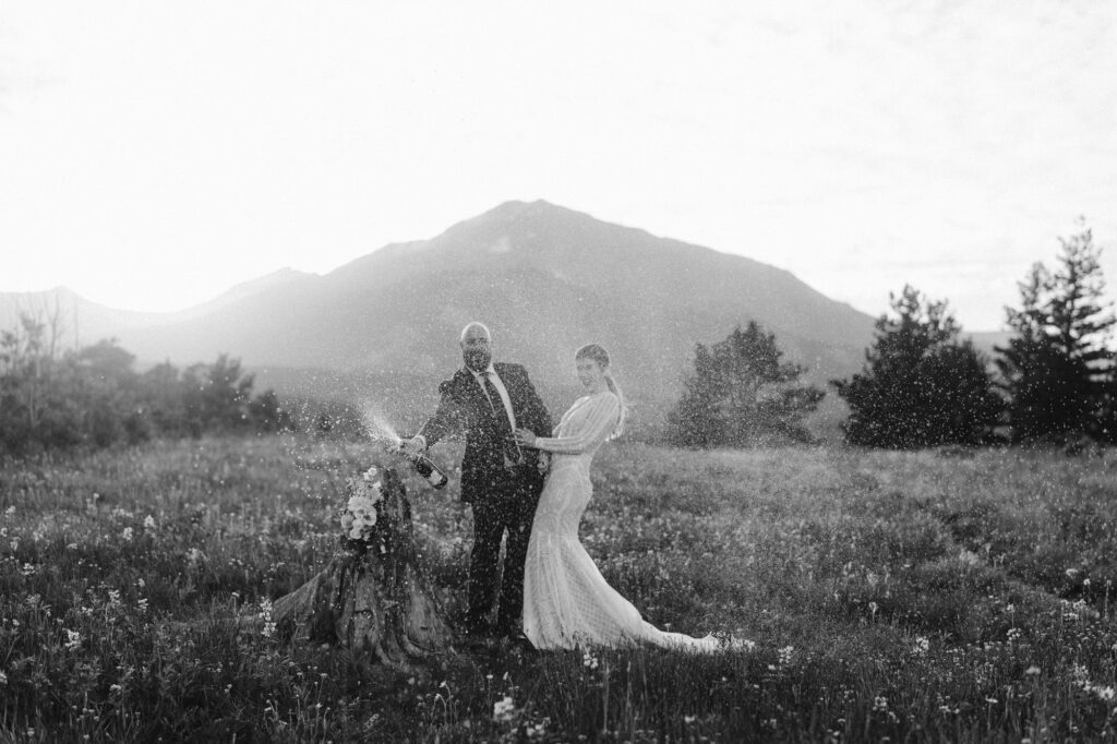 Couple spraying champagne during June Colorado elopement