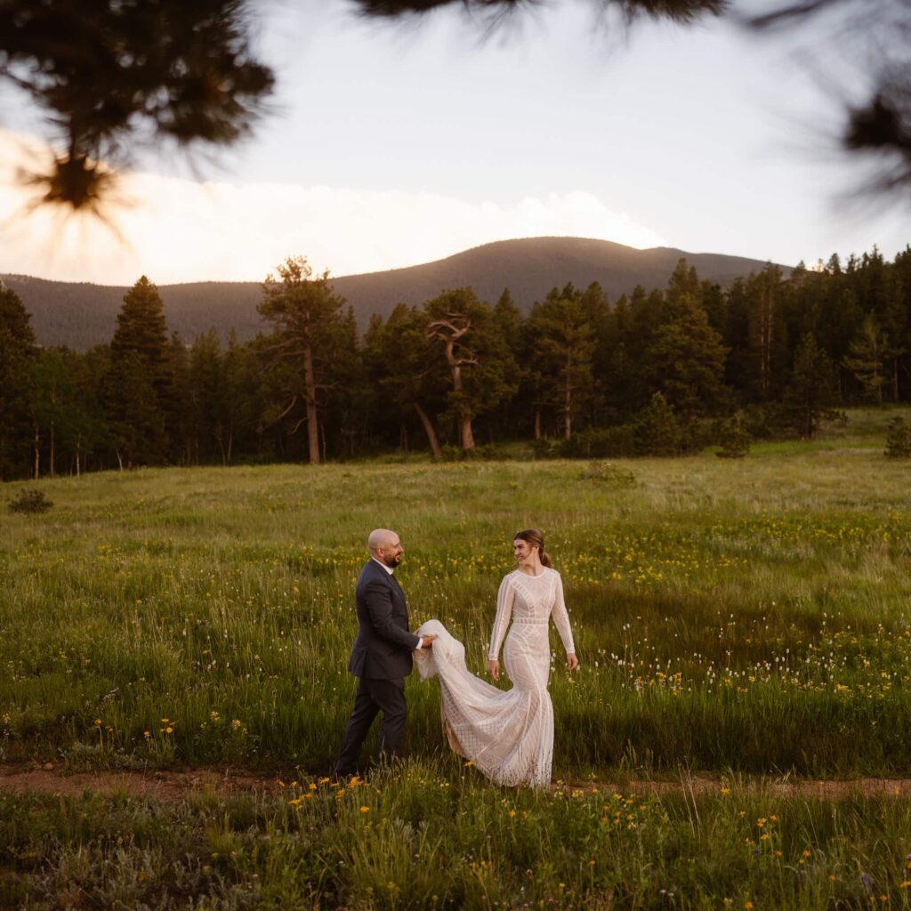 Couple walking down a path of wildflowers at their June elopement