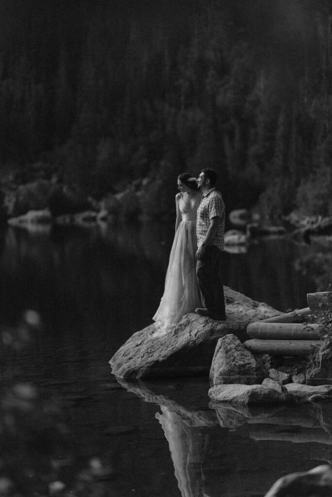 Black and white photo of couple at the edge of Bear Lake with a still reflection