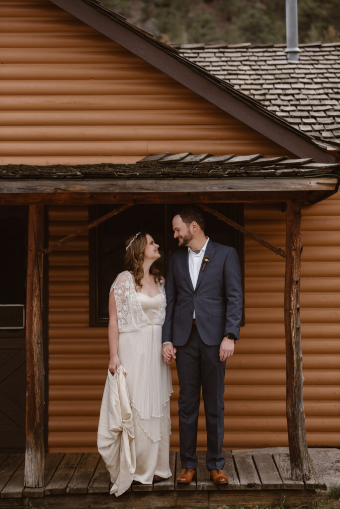 Bride and groom on porch of cabin in Estes Park Colorado on their October wedding day