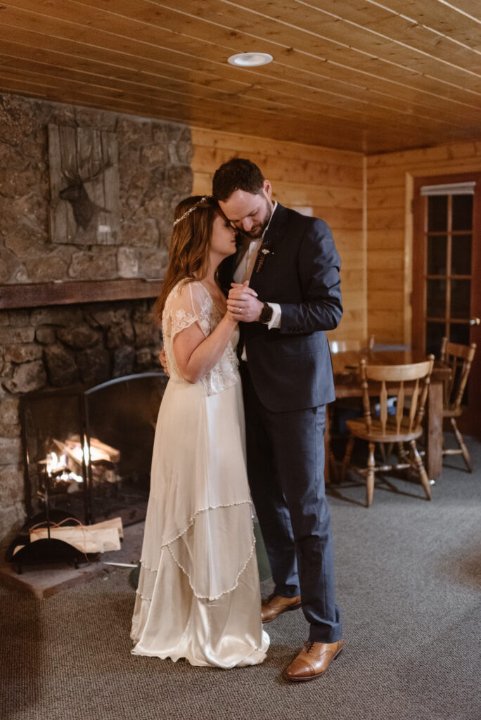 Couple having a first dance in Estes Park cabin in front of the fireplace