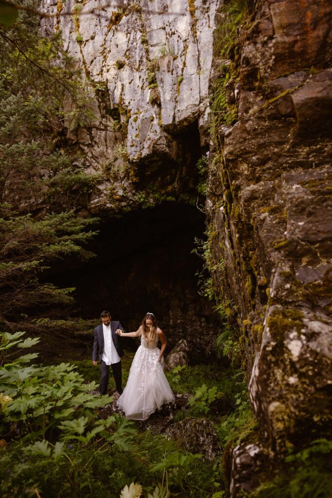 Couple hiking through a cave in Alaska at their adventure elopement