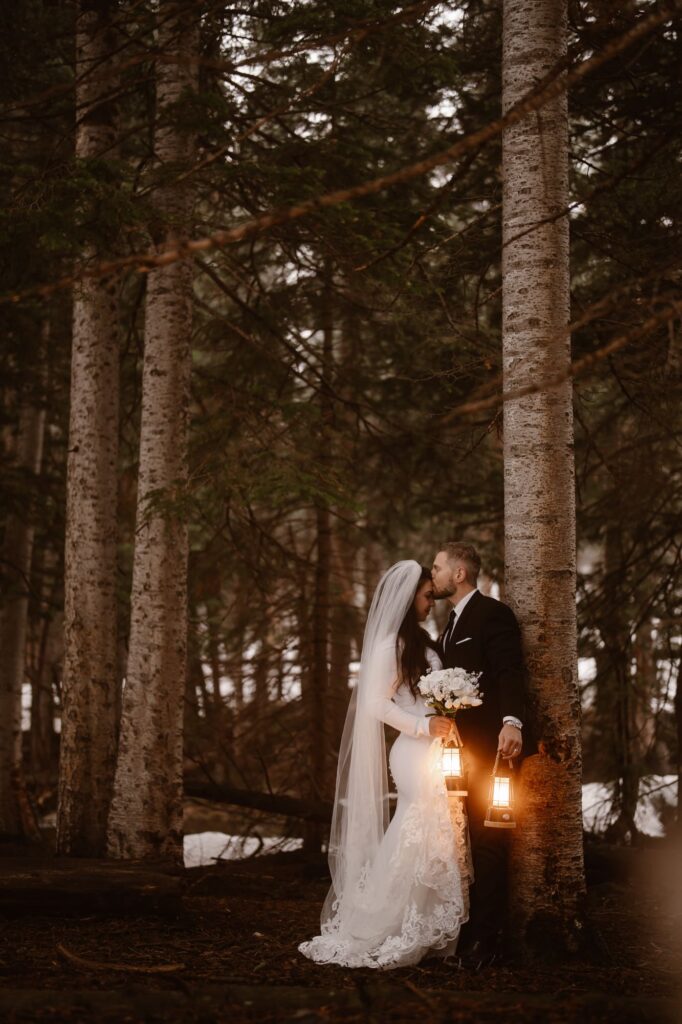 Couple kissing in the forest with glowing lanterns