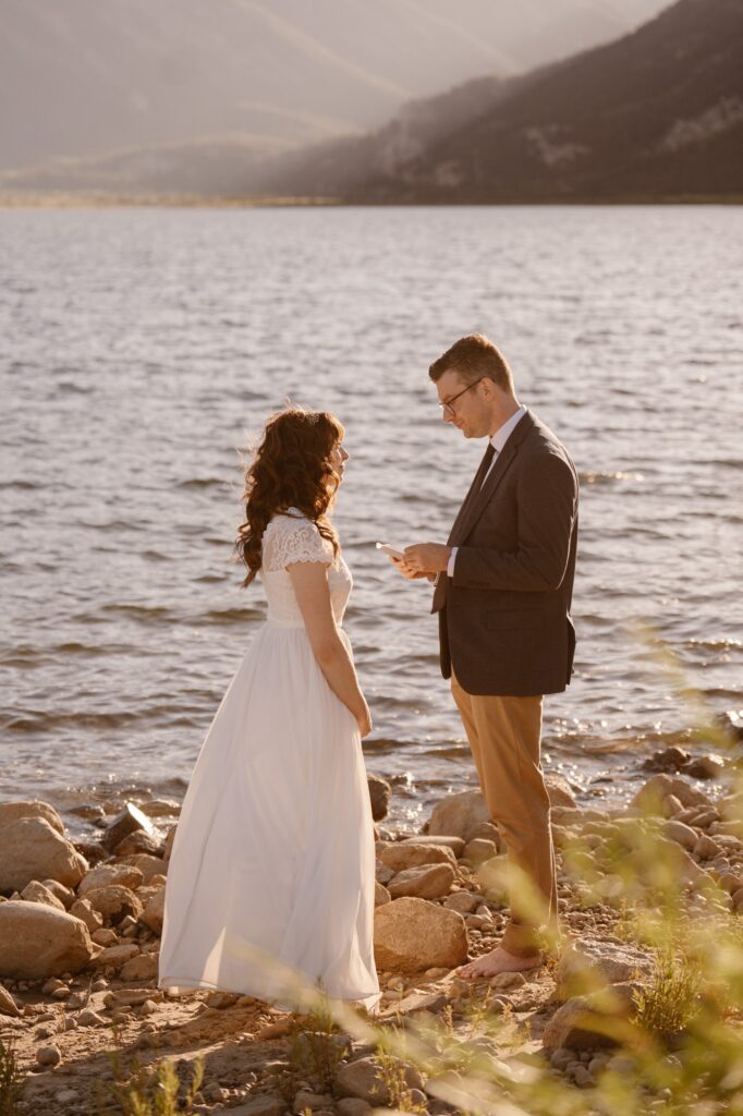 Couple getting married on the shore of a mountain ale