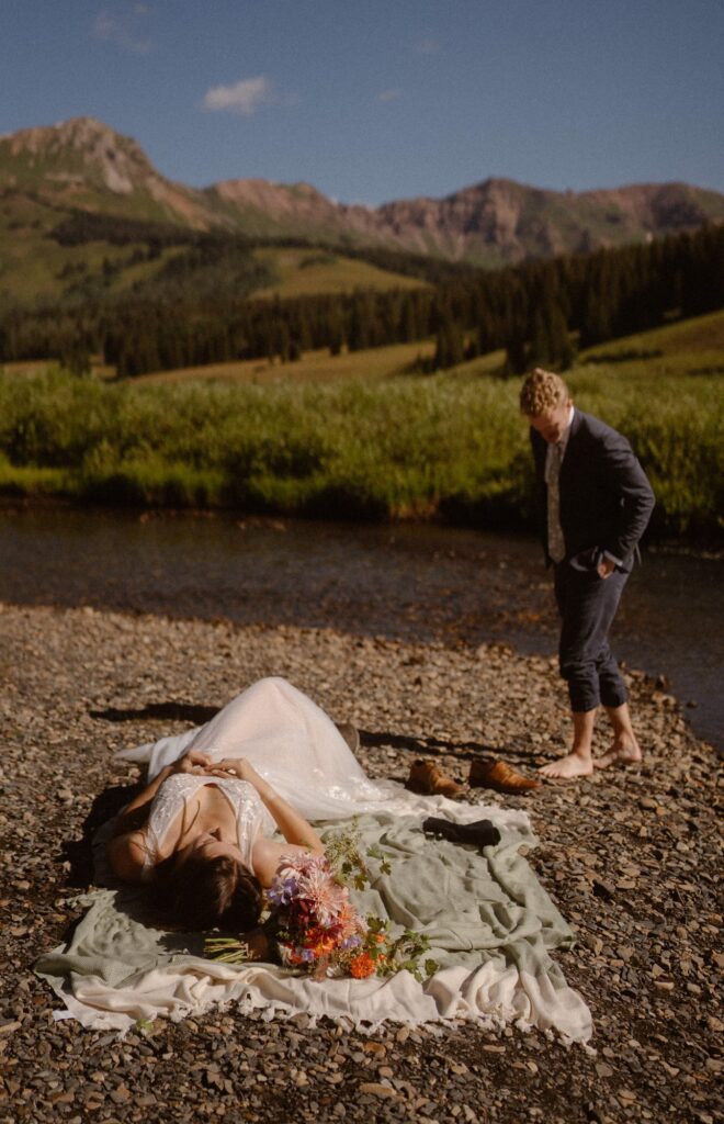 Couple playing in the river on their wedding day