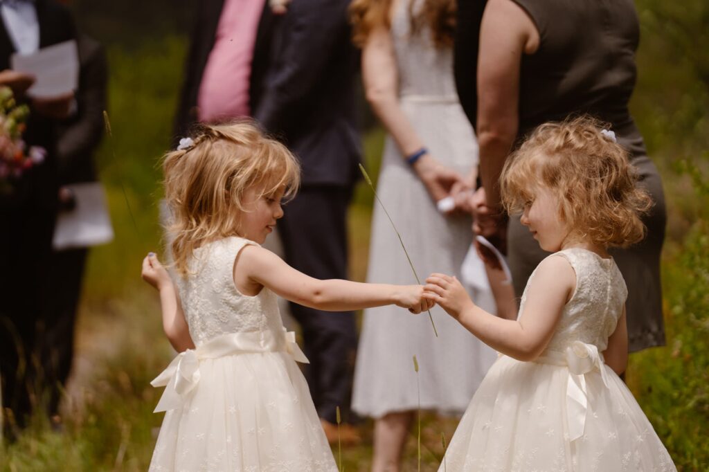 Flower girls playing with grass during the ceremony