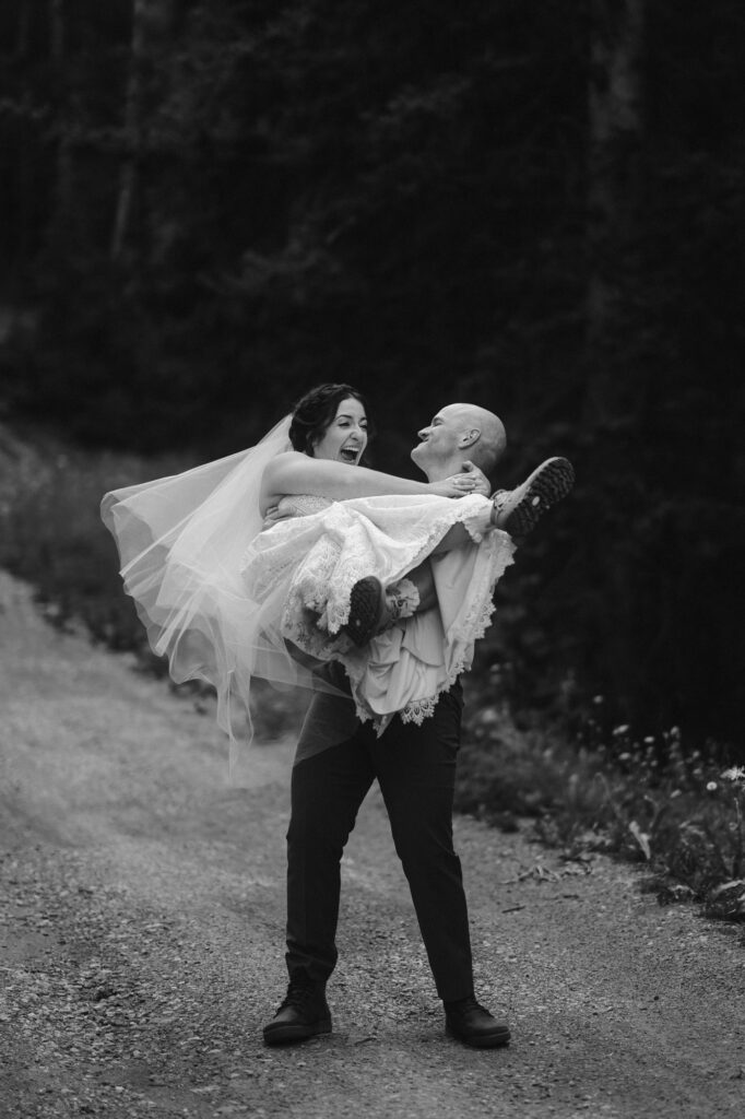 Groom spinning bride around on a dirt road