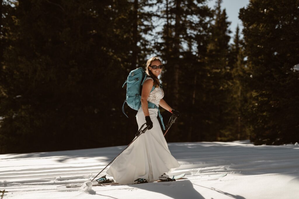 Bride in skis and and a backpack during her elopement day