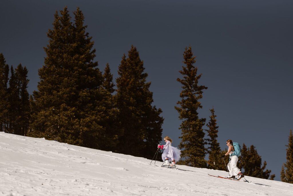 Climbing up the hills on skis in wedding attire