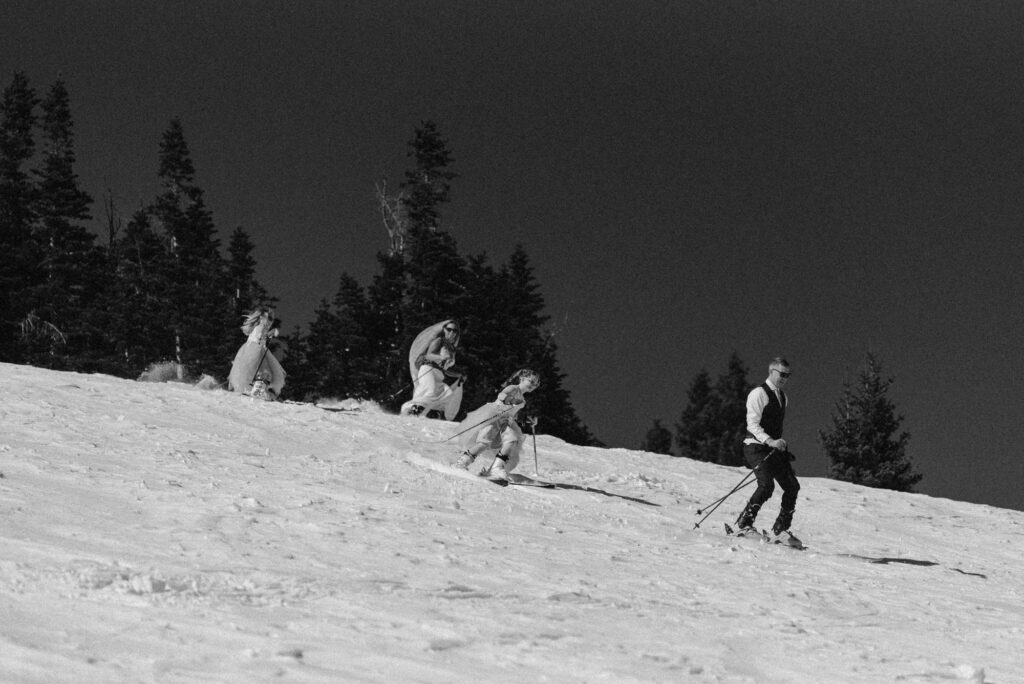 Bride and family ski down hill in Breckenridge on their elopement day