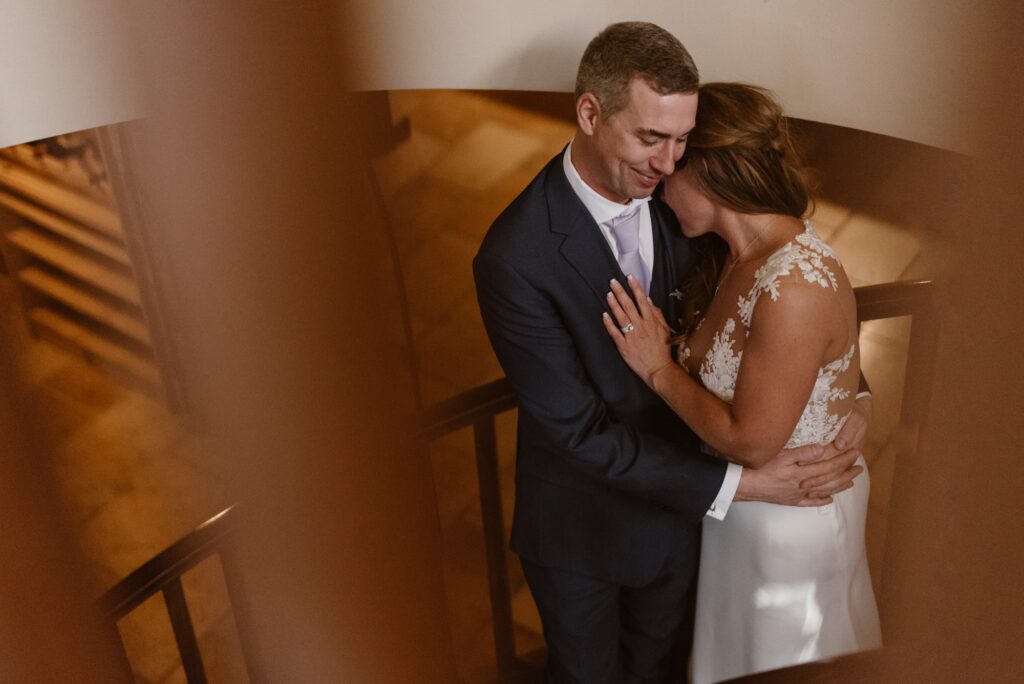 Couple snuggled on spiral staircase