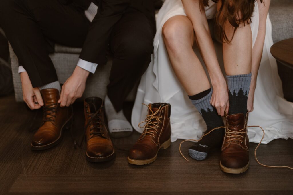 Bride and groom lacing up their hiking boots