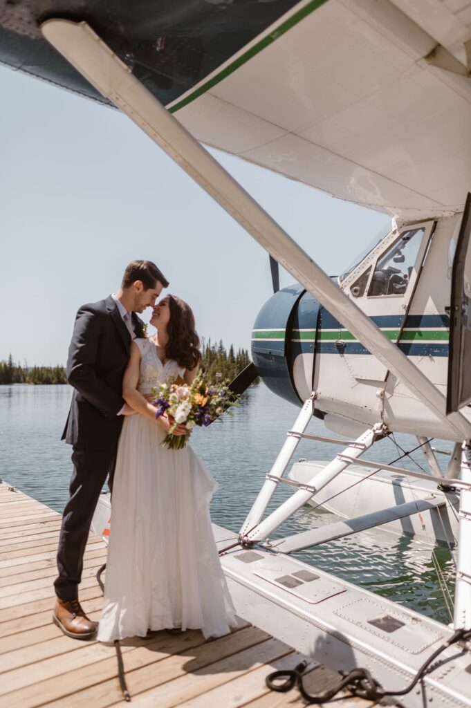 Couple getting off a float plane at a National Park in their wedding attire during their destination elopement