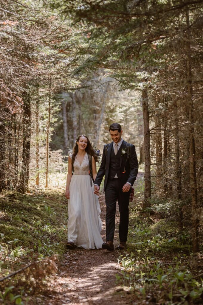 Bride and groom hiking through the forest on their elopement day