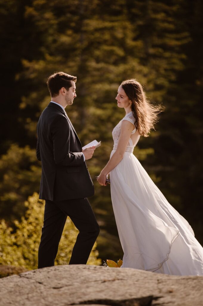 Bride and groom glowing in the sun while reading vows at a remote spot in Isle Royale National Park