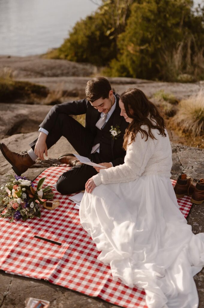 Couple on a picnic blanket reading letters from loved ones