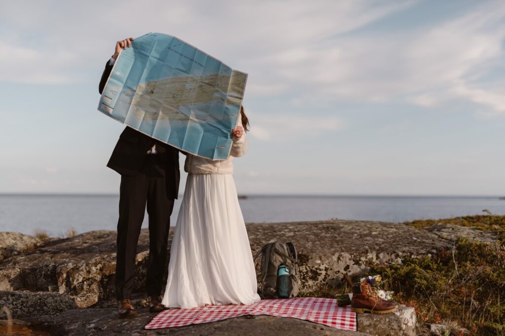 Couple looking at a map with a Wes Anderson vibe on their wedding day