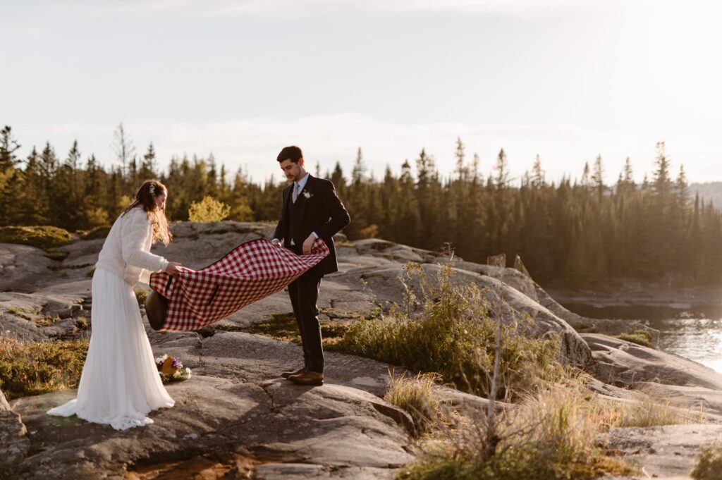 Couple folding up their picnic blanket in the sunlight