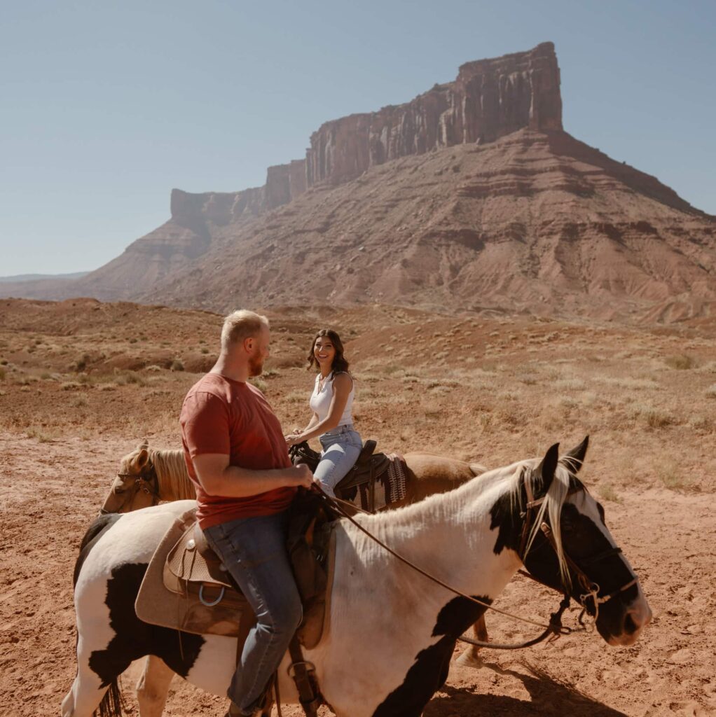 Couple laughing while riding horses at Sorrel River Ranch