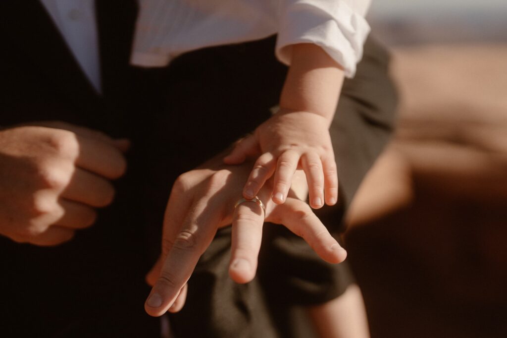 Son touching his dad's wedding ring