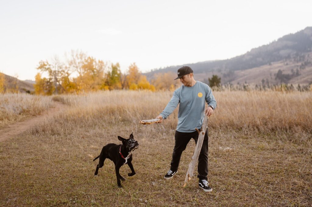 Owner playing with sticks and his dog