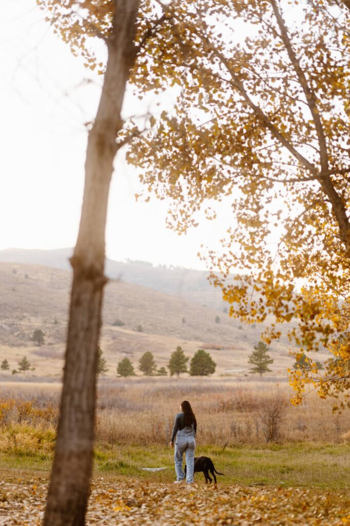 Owner and her dog walking through the Autumn leaves at Lory State Park