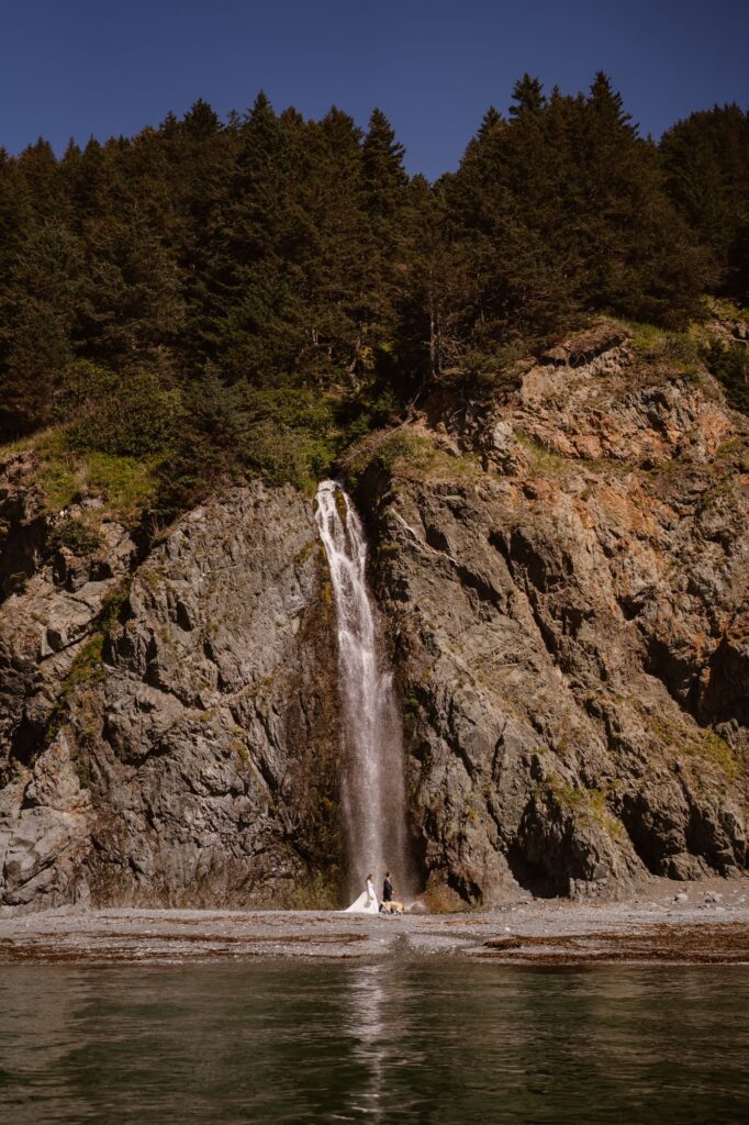 Waterfall in Alaska with bride and groom