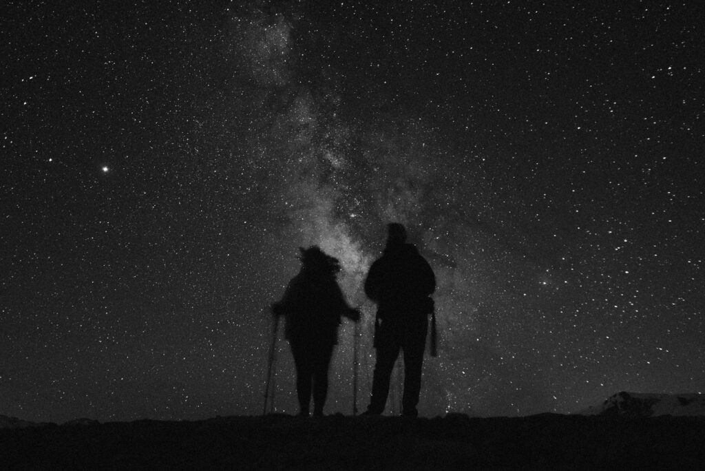 Silhouette of couple standing in front of the brilliant milky way on a romantic date in Estes Park