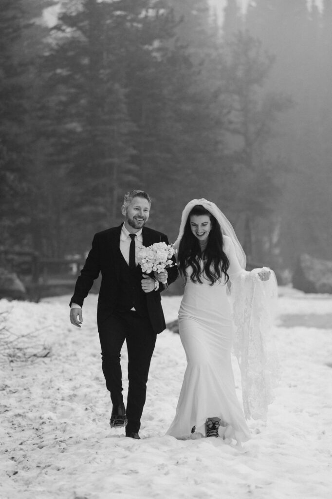Bride and groom walking through the snow at Bear Lake