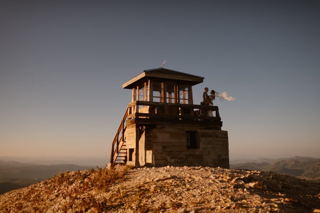 Couple getting married on top of a fire tower for unique wedding photos