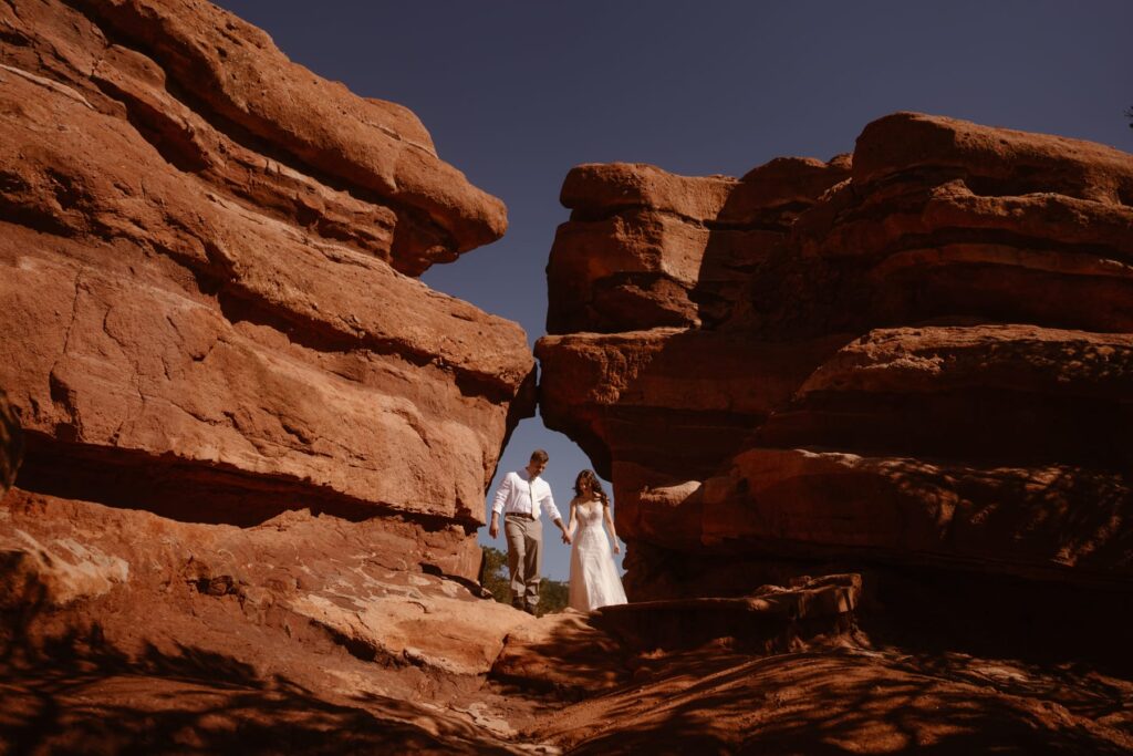 Couple walking through a keyhole in the rocks