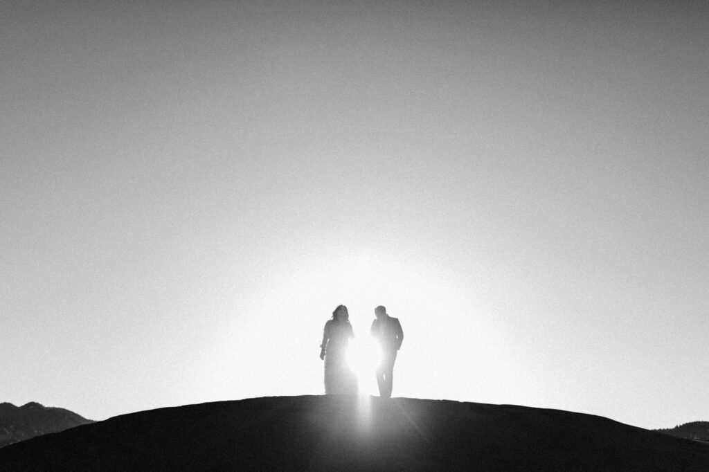 View of couple walking the ridge of the sand dunes