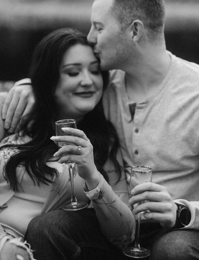 Couple with bubbly water in champagne glass and engagement ring