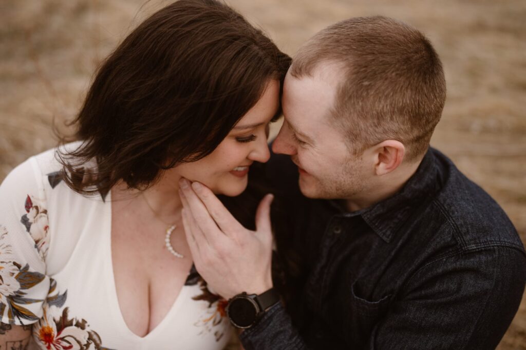 Couple snuggling in the mountains during engagement photos