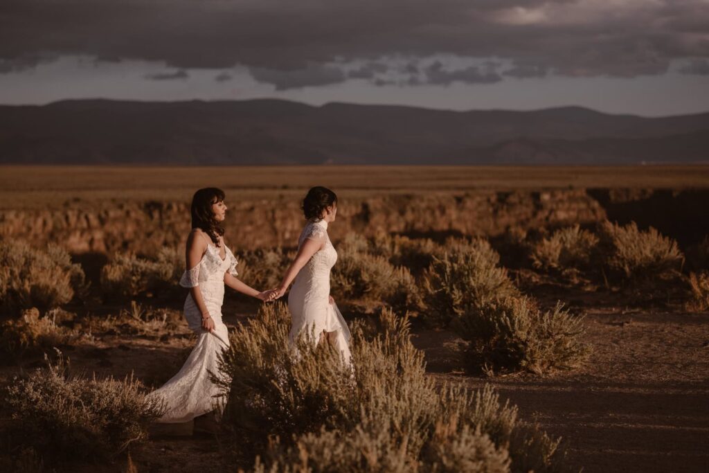 Brides walking in the desert sunset on their wedding day