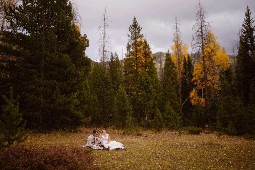 Bride and groom journaling in a meadow in Rocky Mountain National Park