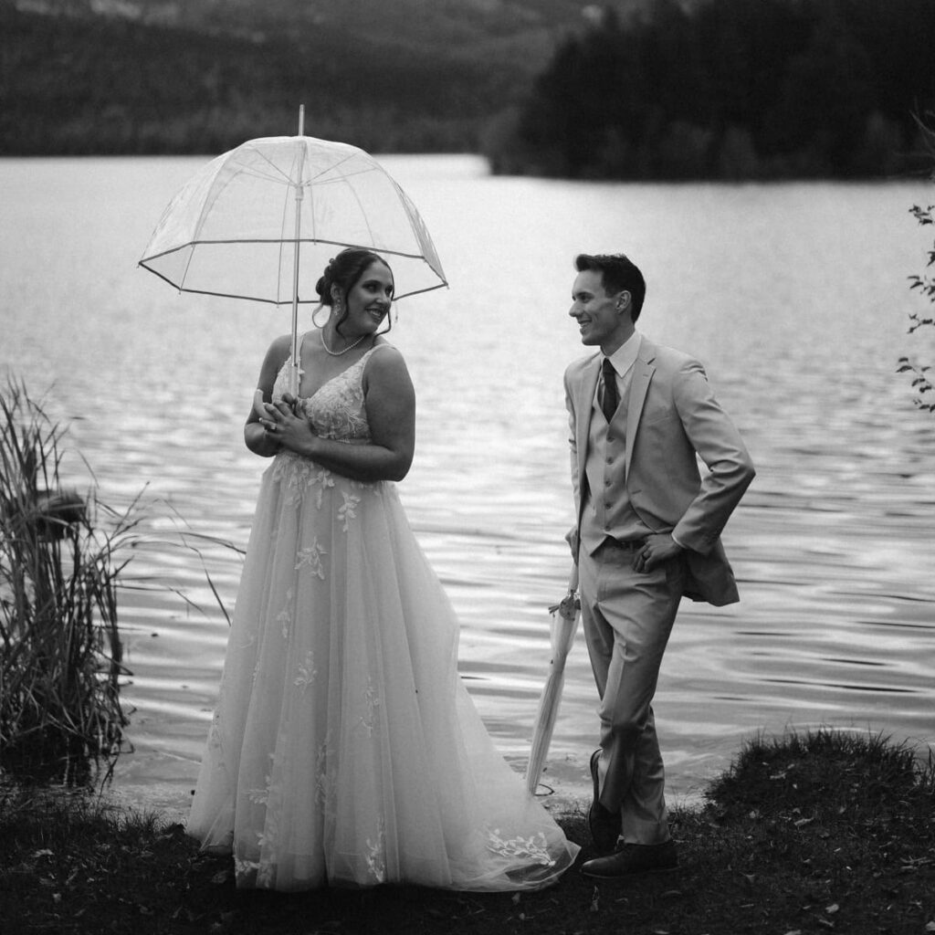 Couple under umbrellas near the lakeshore