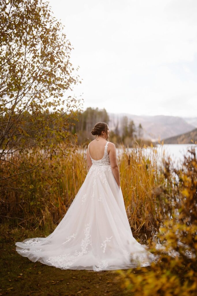 Bride at Grand Lake, Colorado with big wedding dress train