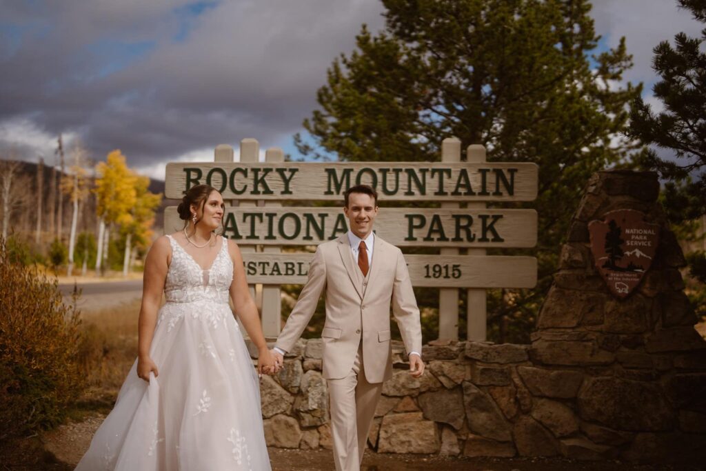 Bride and groom in front of Rocky Mountain National Park sign