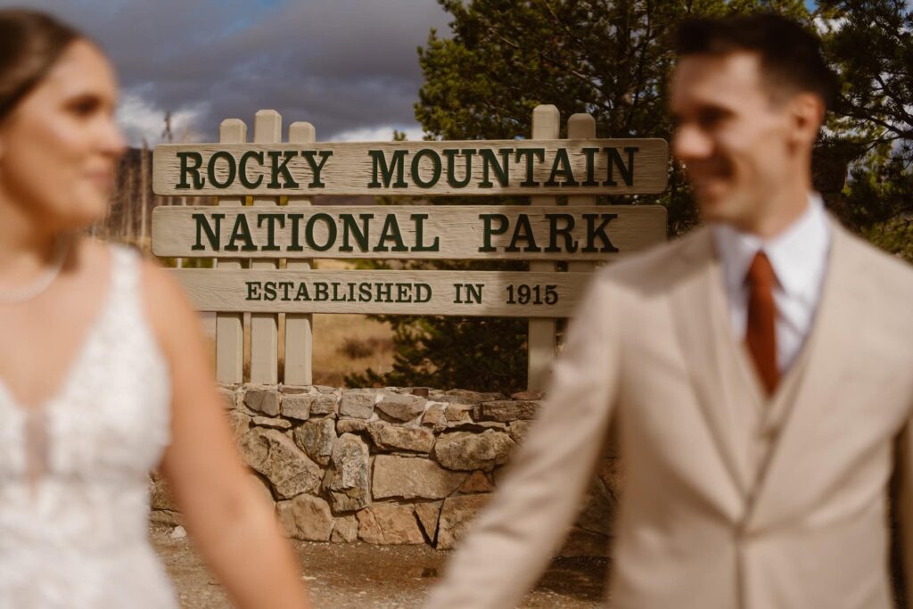 Wedding day portrait in front of Rocky Mountain National Park sign