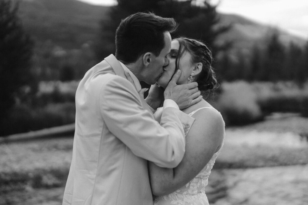 Bride and groom kissing in the mountains