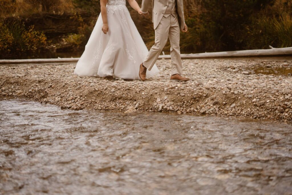 Bride and groom walking along the river