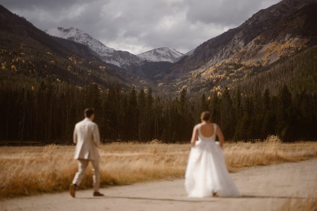 Couple walking down a dirt road in Rocky Mountain National Park on their wedding day