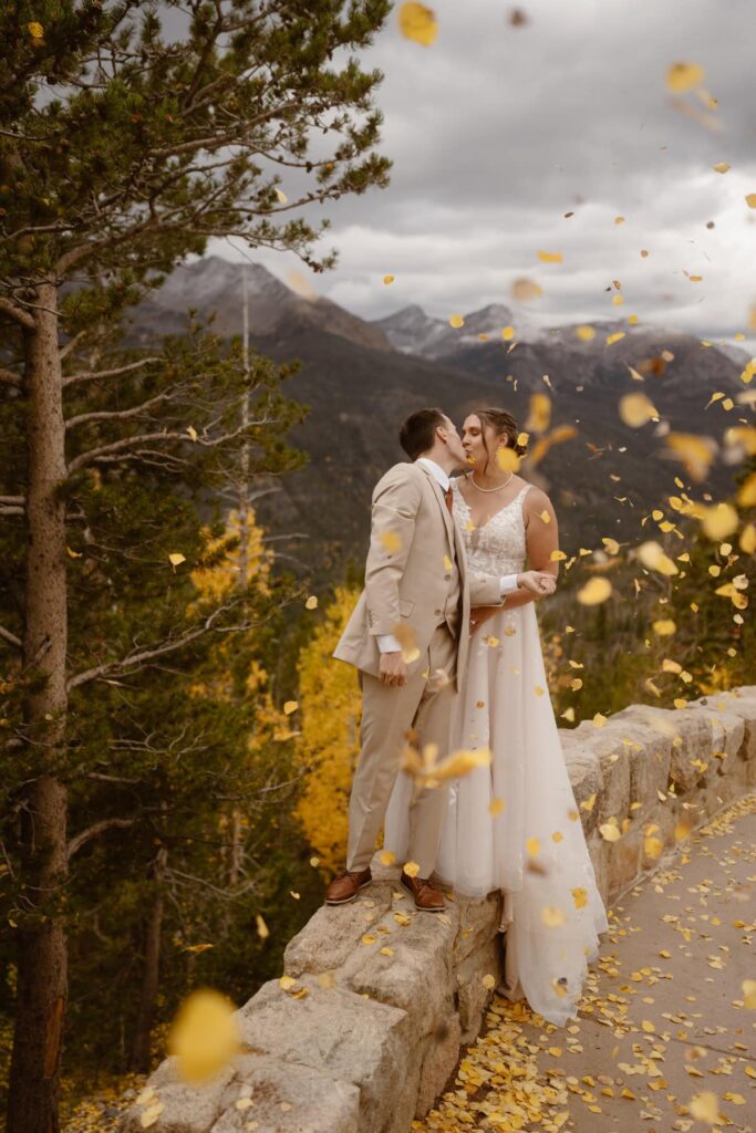 Couple under falling aspen leaves in the mountains