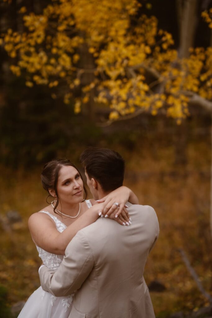 Beautiful yellow aspen leaves and a bride and groom