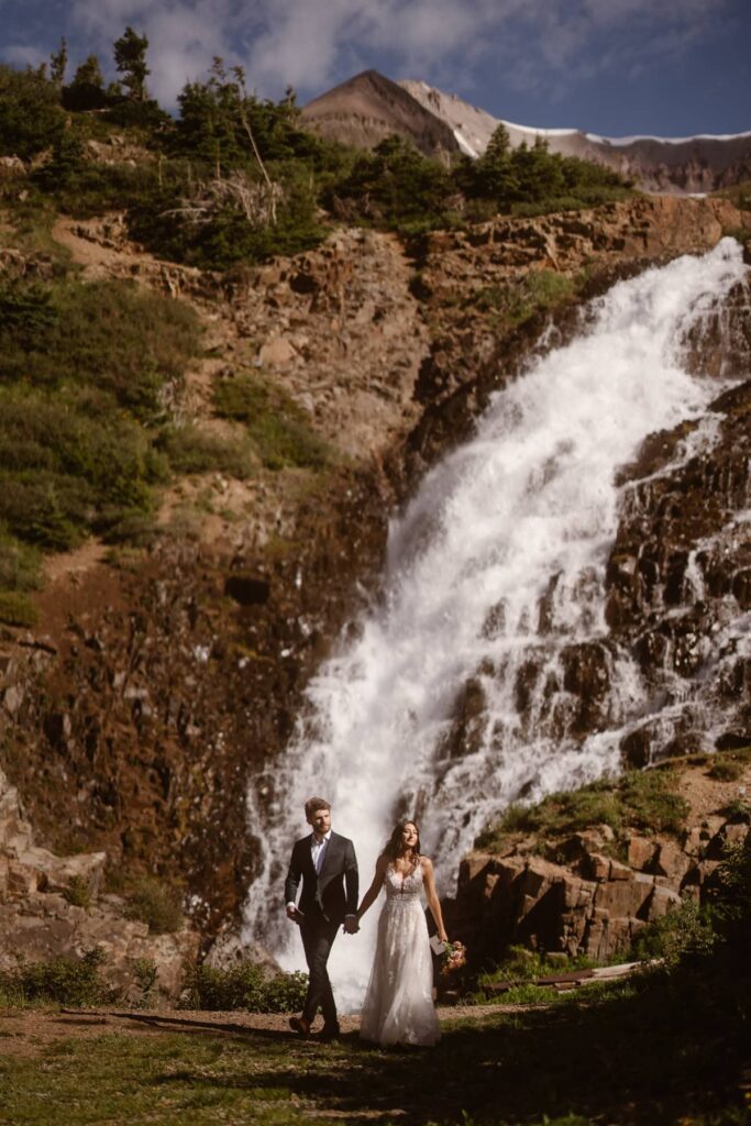 Wedding portraits in front of Colorado waterfall