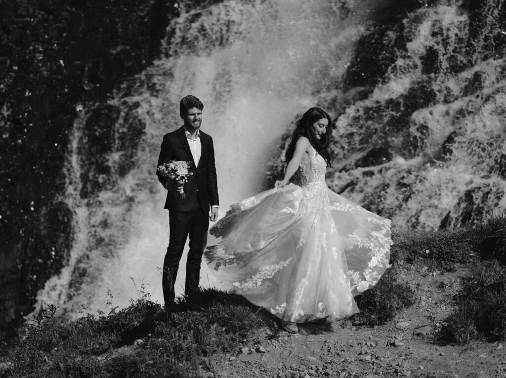 Bride and groom dancing in front of the waterfall