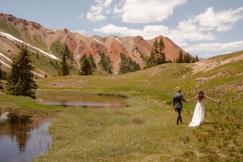 Bride and groom walking through the mountains on their wedding day